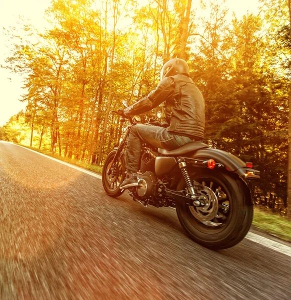 男人坐在摩托车上的林道. — 图库照片