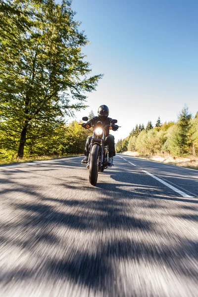 Hombre asiento en la motocicleta en el camino del bosque . — Foto de Stock