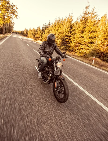 Hombre asiento en la motocicleta en el camino del bosque . — Foto de Stock