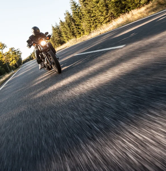 Hombre asiento en la motocicleta en el camino del bosque . — Foto de Stock