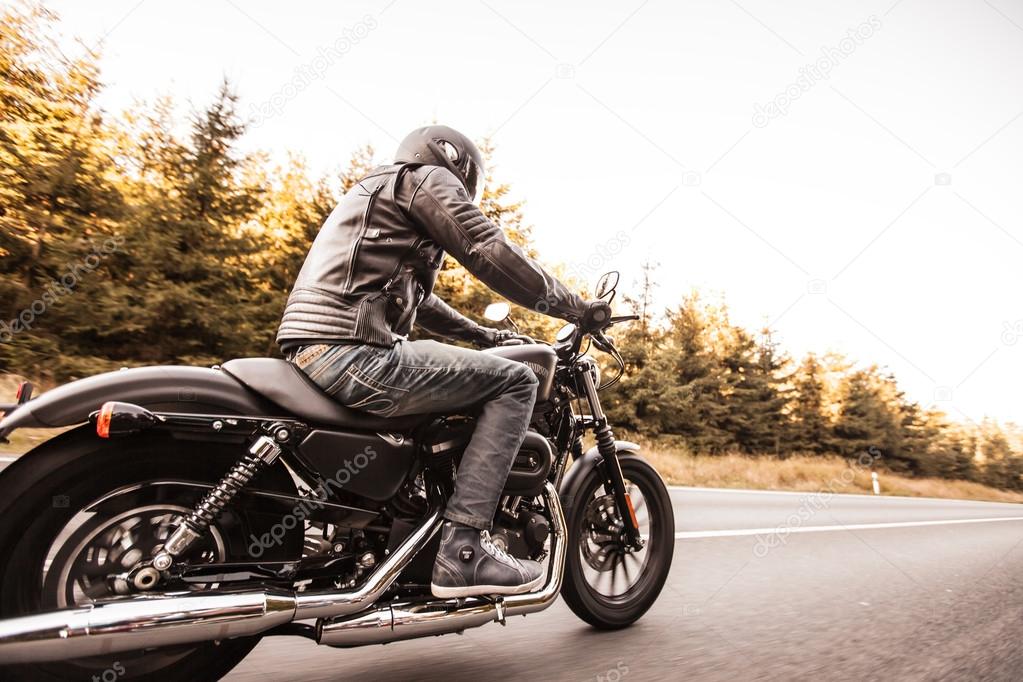 Man seat on the motorcycle on the forest road.