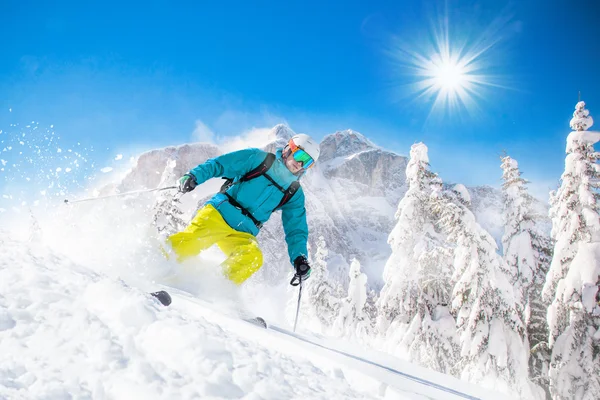 Esquiador esquiando cuesta abajo en las altas montañas —  Fotos de Stock