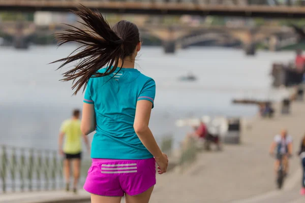 Τρέχοντας γυναίκα κατά τη διάρκεια ηλιόλουστη μέρα στην πόλη. — Φωτογραφία Αρχείου