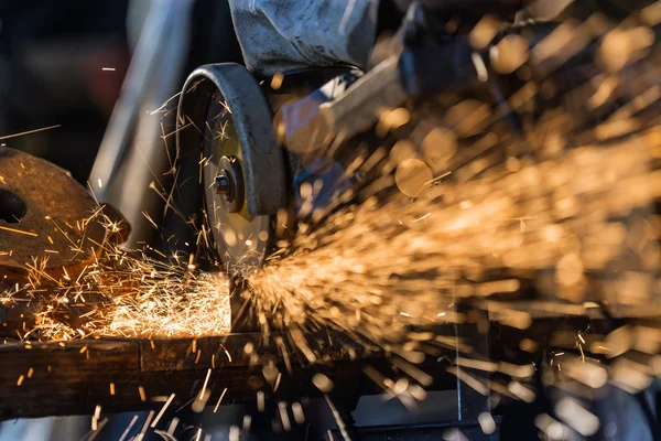 Werknemer die metaal snijdt met slijpmachine. — Stockfoto