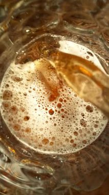 Super Slow Motion of Pouring Beer into Pint Glass, Top Down View. Filmed on High Speed Cinema Camera, 1000 fps.