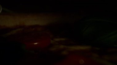 İştah açıcı bir dilim pizza teslimat için hazırlanmış karton bir kutunun içinde, kamera pizzanın hemen üstünden geçiyor.