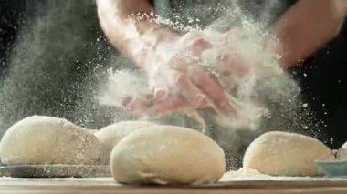 Bir fırıncının ellerini çırpıp etrafa un fırlatmasının süper yavaş hareketi. High Speed Cinema Camera 'da çekildi, 1000 fps. Hamur Hazırlığının Kapanışı.