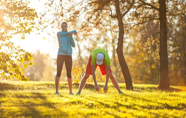 Man och kvinna utbildning utanför under höstdag. — Stockfoto