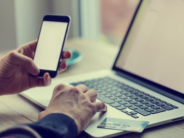 Kredi kartı ile defter üzerinde çalışan adam.