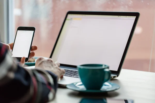 Man working on notebook, with a fresh cup of coffee and cell phone. — Stock Fotó