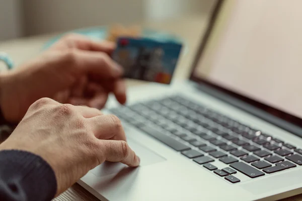 Man aan het werk op laptop met credit card. — Stockfoto