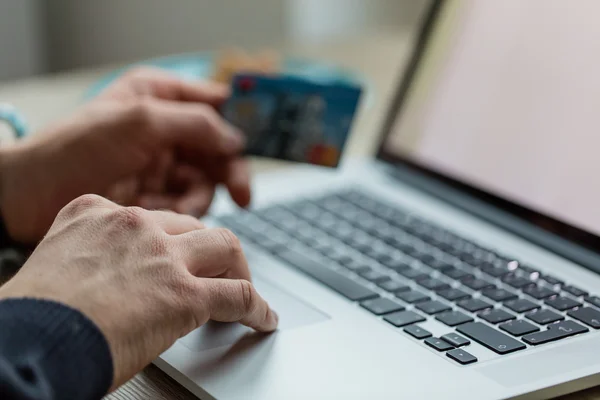 Hombre trabajando en cuaderno con tarjeta de crédito . — Foto de Stock