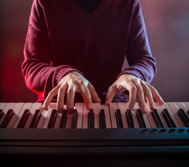 Mans hand playing piano. clipart