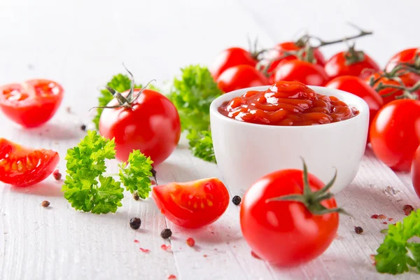 Tigela de molho de tomate e tomate cereja na mesa de madeira . — Fotografia de Stock