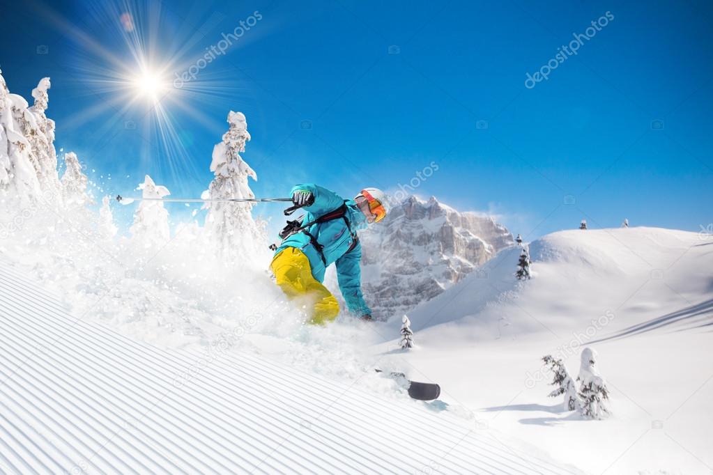 Skier skiing downhill in high mountains