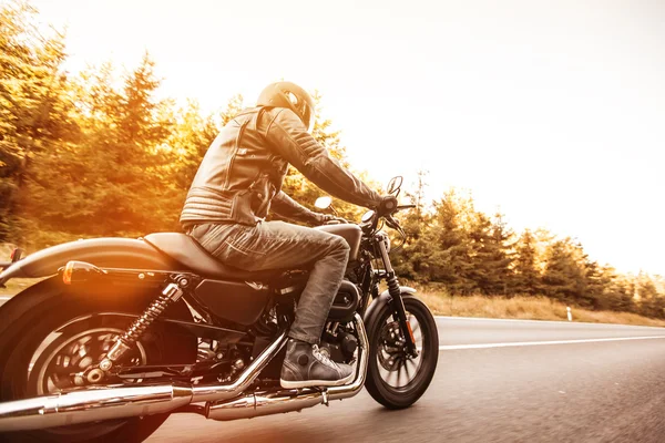 Homem assento na moto na estrada da floresta . — Fotografia de Stock