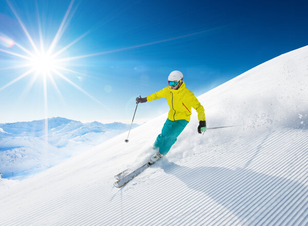 Skier skiing downhill in high mountains