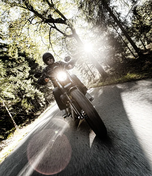 Männersitz auf dem Motorrad auf der Forststraße. — Stockfoto