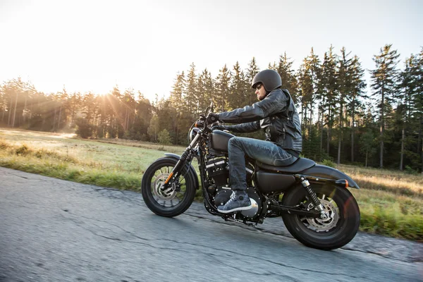 Hombre asiento en la motocicleta en el camino del bosque . —  Fotos de Stock