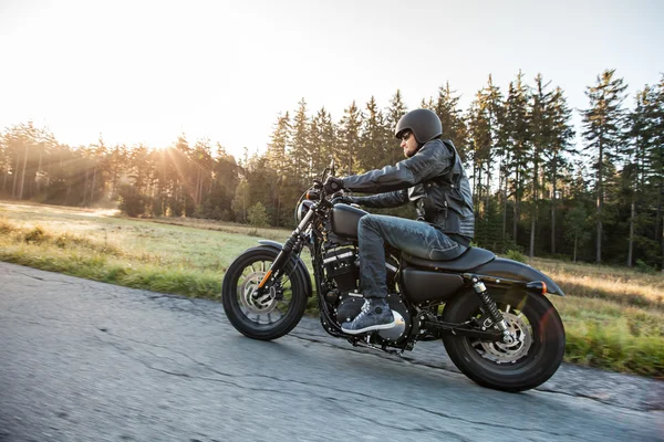 Männersitz auf dem Motorrad auf der Forststraße. — Stockfoto