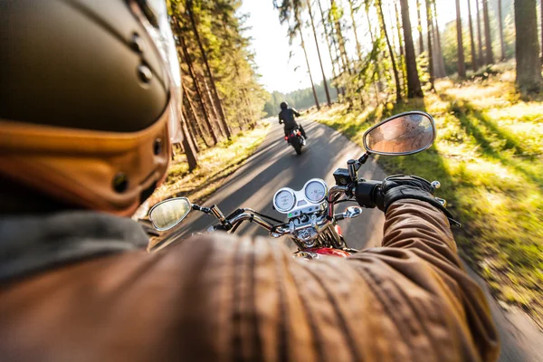 Чоловік сидить на мотоциклі на лісовій дорозі . — стокове фото