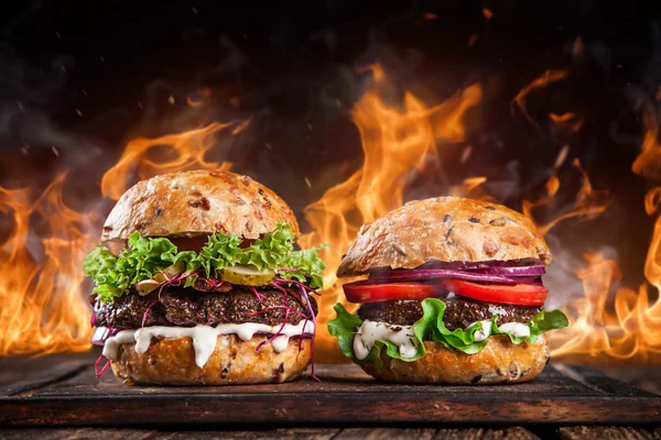 Home made burgers with fire flames. — Stockfoto