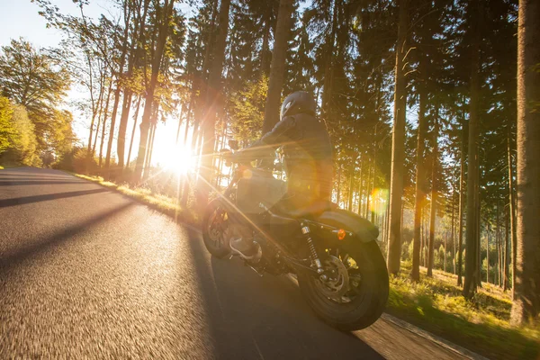 Homem assento na moto na estrada da floresta . — Fotografia de Stock