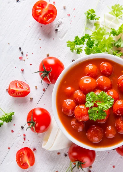 Tigela de molho de tomate e tomate cereja na mesa de madeira . — Fotografia de Stock