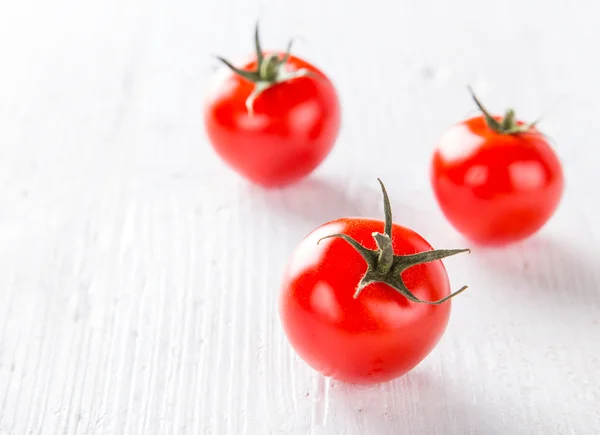 Tomates de cereja frescos em uma mesa de madeira — Fotografia de Stock