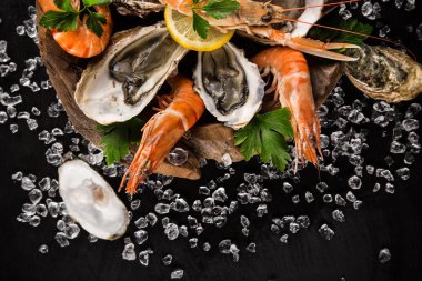 Siyah taş üzerinde taze deniz ürünleri.