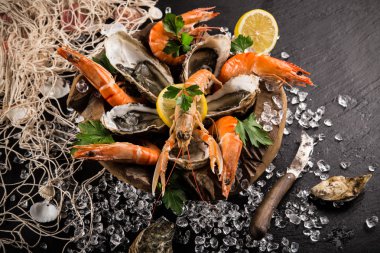 Siyah taş üzerinde taze deniz ürünleri.