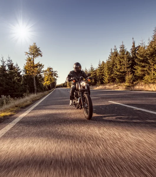 Hombre asiento en la motocicleta en el camino del bosque . — Foto de Stock