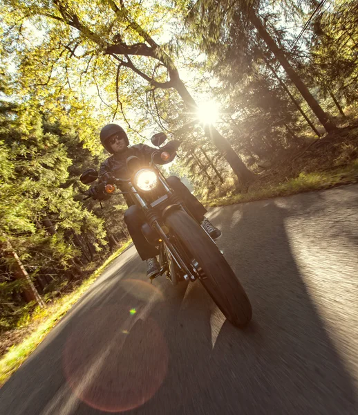 Hombre asiento en la motocicleta en el camino del bosque . — Foto de Stock