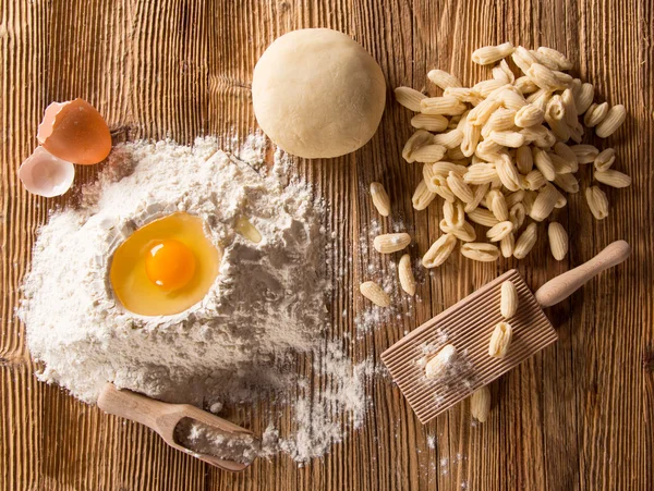 Massa caseira rigate com ovo, farinha em uma mesa de madeira — Fotografia de Stock