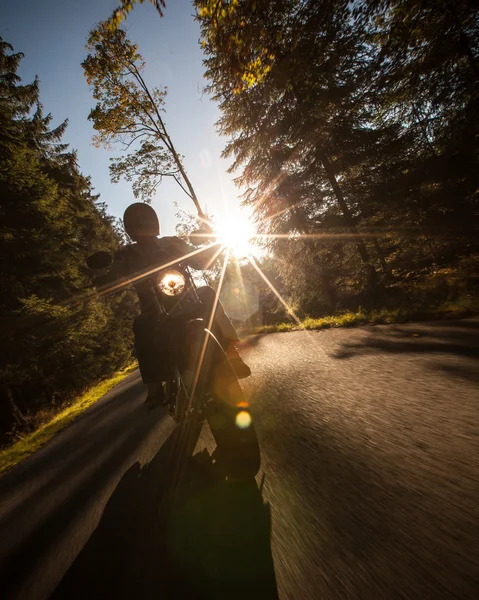 Man seat on the motorcycle on the forest road.