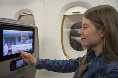 genç kadın yolcunun onboard dokunmatik ekranın kullanılması