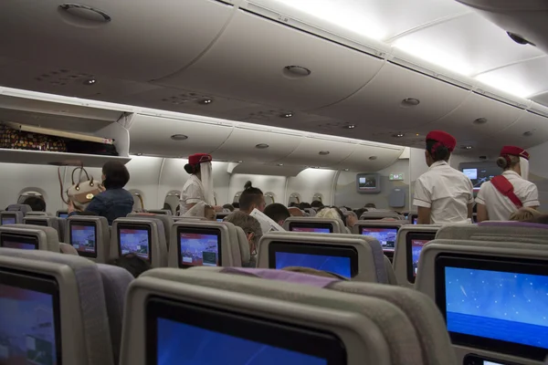 Asistentes de vuelo y pasajeros a bordo — Foto de Stock