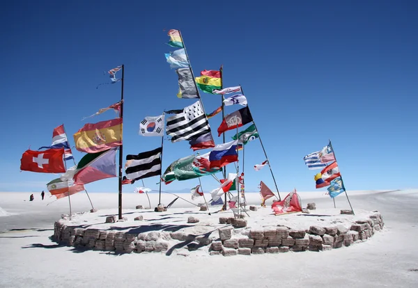 Bandiere in un deserto salato di Salar de Uyuni — Foto Stock