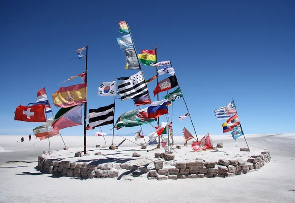 Vlajky v solné poušti Salar de Uyuni — Stock fotografie