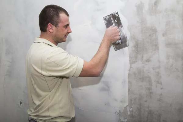 Uomo lavoratore utilizzando galleggiante per applicare il primo strato di stucco — Foto Stock