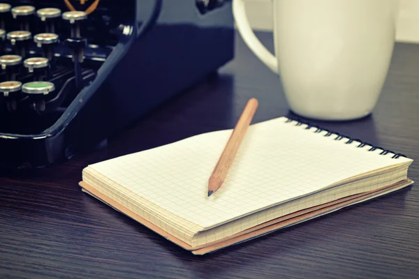 Libreta en blanco, taza y máquina de escribir vintage —  Fotos de Stock