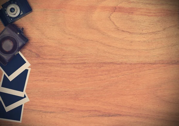 Cámara vintage y estuche con tarjeta fotográfica en blanco en mesa de madera — Foto de Stock