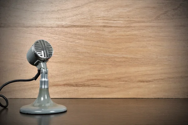 Старый старинный микрофон, стоящий на деревянном столе — стоковое фото