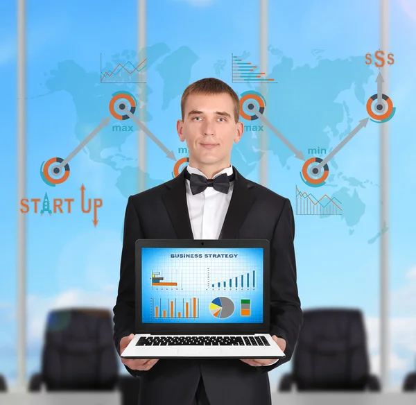 Zakenman permanent in kantoor en laptop met business strategie houden op scherm — Stockfoto