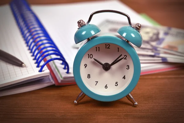 Alarm clock, note pad and money on table, close up — Stock Photo, Image