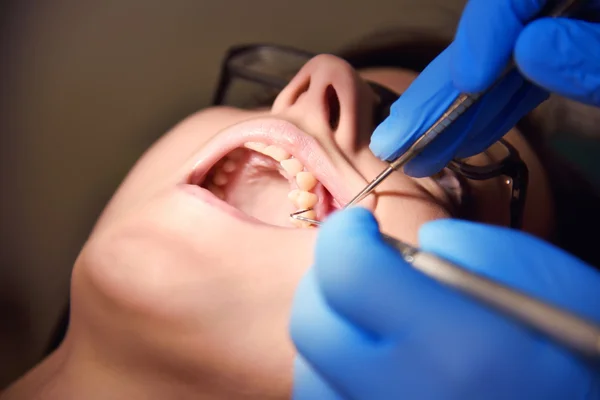 Dentist examining a patient's teeth — Stock Photo, Image