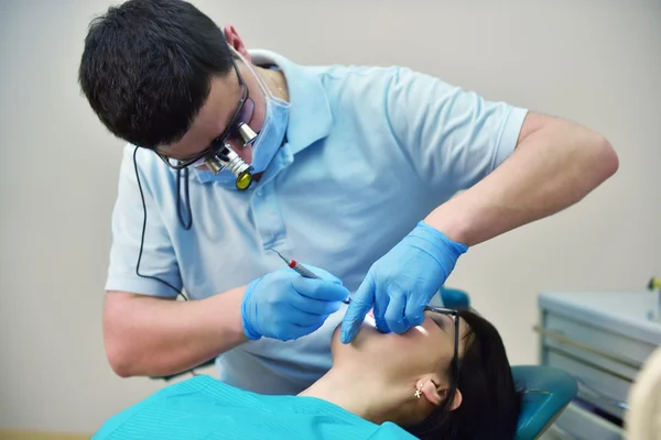 Tandläkaren undersöker tänderna — Stockfoto