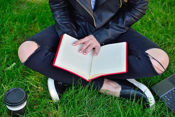 Meisje zittend op gras en het lezen boek — Stockfoto