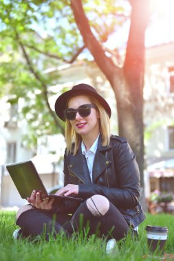 dizüstü bilgisayar ile çim üzerinde oturan kız