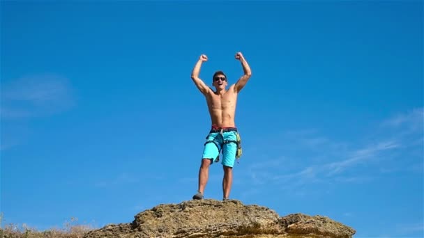 Extrême grimpeur levant les mains sur le sommet de la montagne . — Video